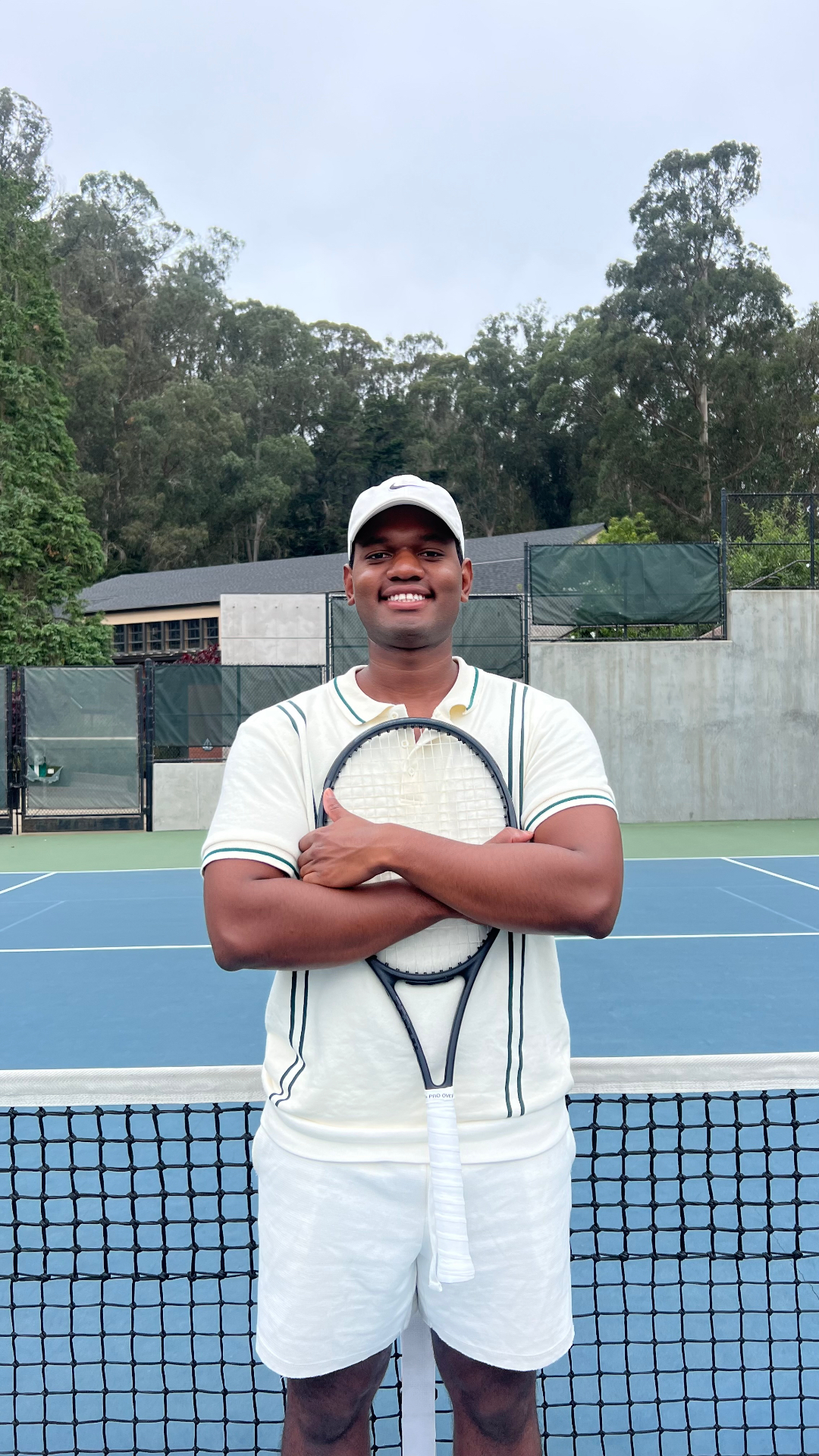 Heitor Garcia, tennis coach, on court holding a racquet
